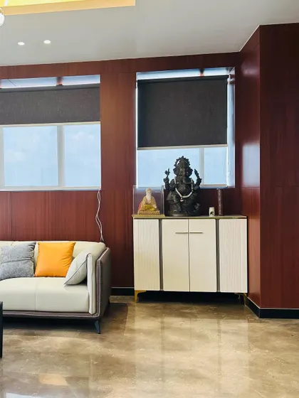 A section of the MD's waiting area, featuring a white credenza for storage. A Ganesha idol is placed on top, adding a traditional and auspicious element to the modern corporate space.