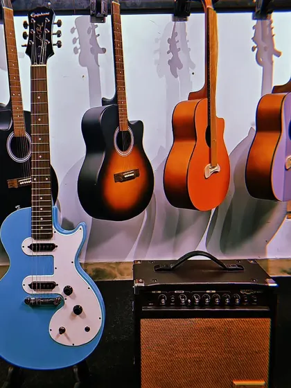 The Epiphone Les Paul SL in a striking blue finish, paired with a practice amp. This guitar offers the classic Les Paul look and feel in a lightweight, accessible package.