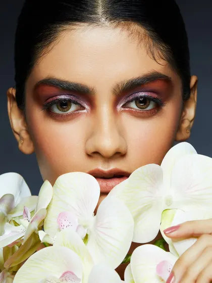 A soft, romantic look with a wash of purple eyeshadow, beautifully complemented by white orchids.