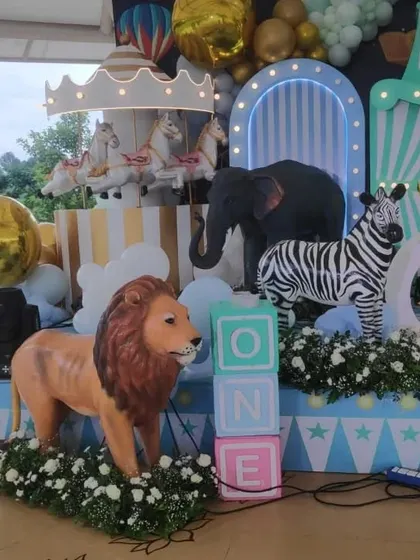 A detailed shot of the pastel circus stage, focusing on the life-size lion prop and "ONE" blocks for a first birthday.