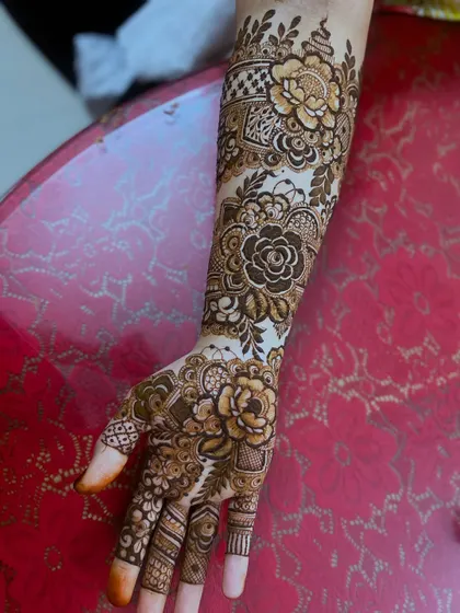 A detailed shot of a signature floral design on the arm. The combination of flowers, leaves, and geometric patterns creates a rich and complex look.