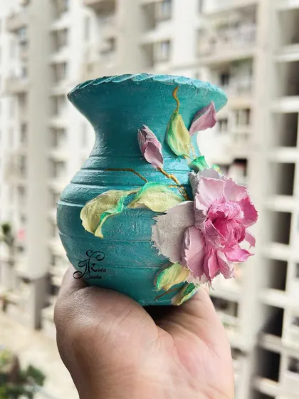 A side profile of the teal vase, highlighting the sculpted leaves and buds.