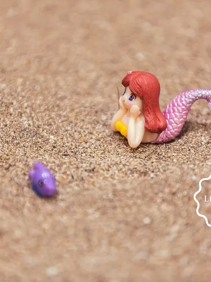 Another tiny mermaid figure waiting to be discovered in the sand.