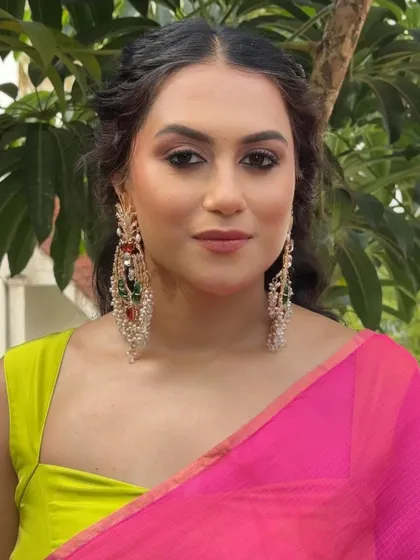 A close-up on the dramatic eye makeup and statement chandelier earrings.