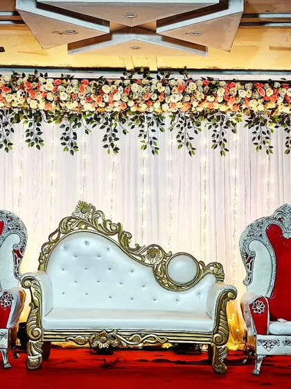 For just 10,000/-, you can have this traditional stage setup with a floral backdrop, a classic white and gold sofa, and matching royal chairs. It's a perfect example of how I deliver quality even on a tight budget.