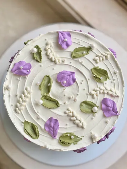 A top-down view of the wildflower cake, showcasing the artistic arrangement of the purple and white blooms.