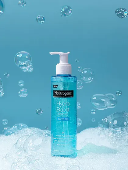 A conceptual shot for Neutrogena's Hydro Boost cleanser, using suspended bubbles against a clean blue backdrop. The styling creates a sense of weightlessness and deep, bubbly cleansing action.