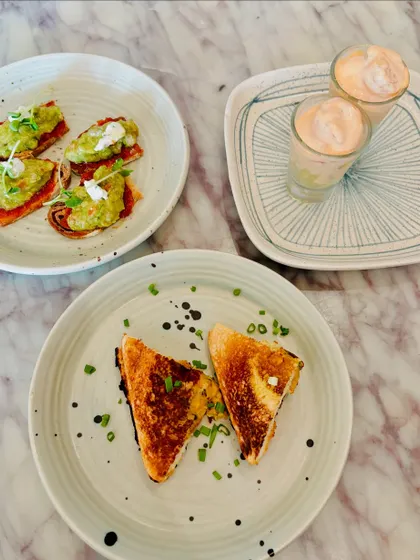A trio of brunch bites: avocado toast, grilled cheese, and a creamy shrimp cocktail.