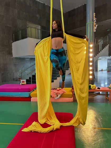 A beautiful, flowing pose where the aerialist uses the fabric to create elegant shapes. Our classes blend athletic skill with creative expression.