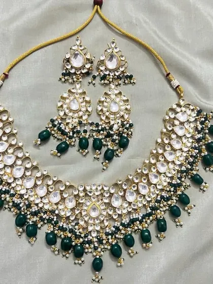 A high-quality Kundan necklace set with dark green beads. This rental set includes a wide necklace and matching earrings, perfect for a reception or wedding.