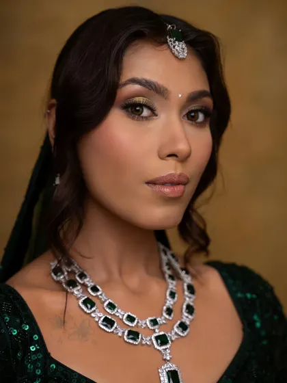 A close-up showcasing the detailed eye makeup with a pop of gold. The soft contouring and luminous skin finish give the face a sculpted yet natural dimension.