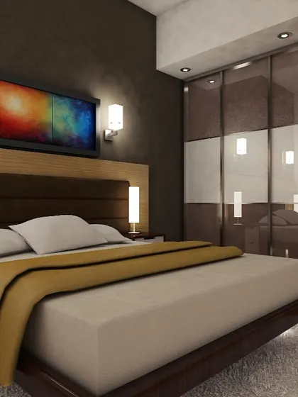 A sophisticated bedroom with a dark color palette, featuring a modern bed with an integrated headboard and side tables. The sliding wardrobe has reflective panels, making the room feel more spacious.