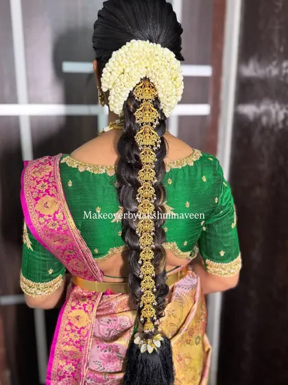 A stunning traditional bridal hairstyle with a long, decorated braid and fresh jasmine flowers.