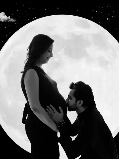 A creative and magical silhouette portrait. The couple is framed against a full moon, creating a stunning and artistic image.