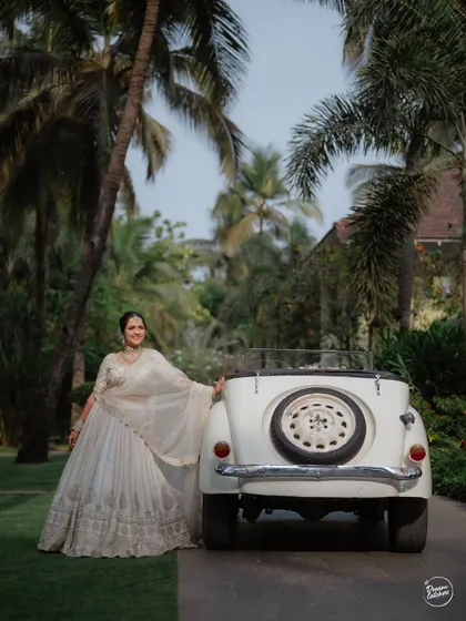 The bride posing with a vintage car, adding a touch of classic charm to her Goa wedding portraits.