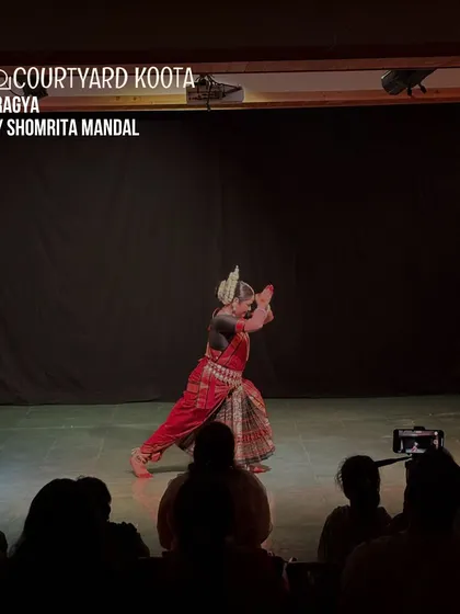 A solo Odissi performance, "Pragya," by Shomrita Mandal. The image captures a moment of pure grace and form against the simple, dark backdrop of our stage, allowing the artist to shine.