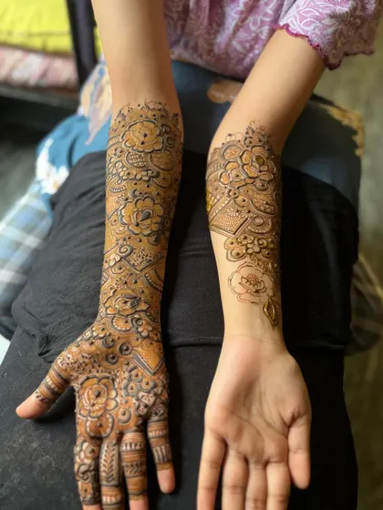 A full-arm Arabic design on one arm, with a simpler pattern on the other.