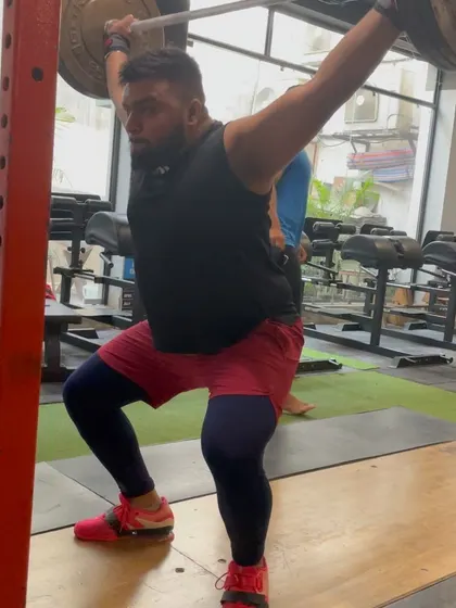 An athlete caught in the bottom of a drop snatch. This image perfectly illustrates the mobility and stability required in the hips, shoulders, and ankles to perform the snatch correctly.