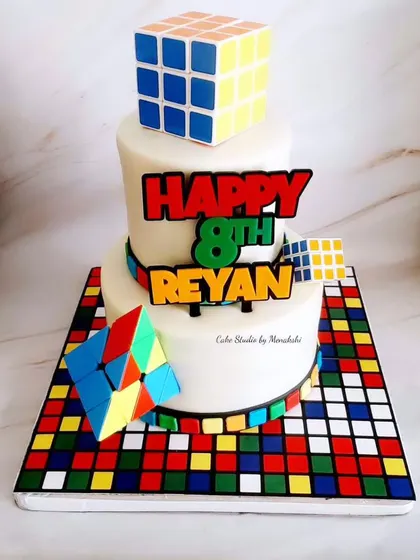 A stunning Rubik's Cube themed cake for an 8th birthday. This two-tier cake is a colourful and clever design for a puzzle-loving kid.