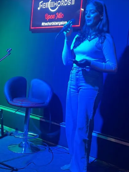 A singer confidently performs for the crowd at our Open Mic event. We provide the stage and support for artists to connect with an audience.