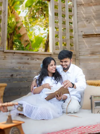 A sweet moment of a couple looking through a photo album together in a cozy, rustic cabin set, perfect for telling the story of their journey.