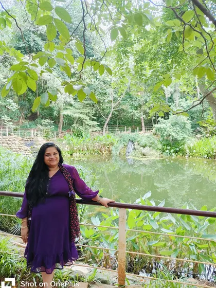 A guest enjoys a quiet moment by a pond, surrounded by the lush greenery of the resort.