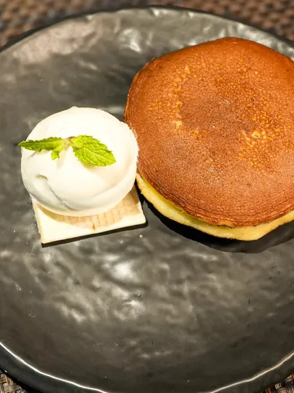 A classic Dorayaki, which is a Japanese pancake sandwich, served with a scoop of ice cream. A simple, comforting, and sweet treat.