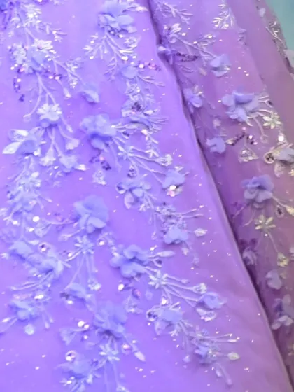 The delicate branches and blossoms embroidered onto this lavender gown are inspired by the beauty of a garden in full bloom.