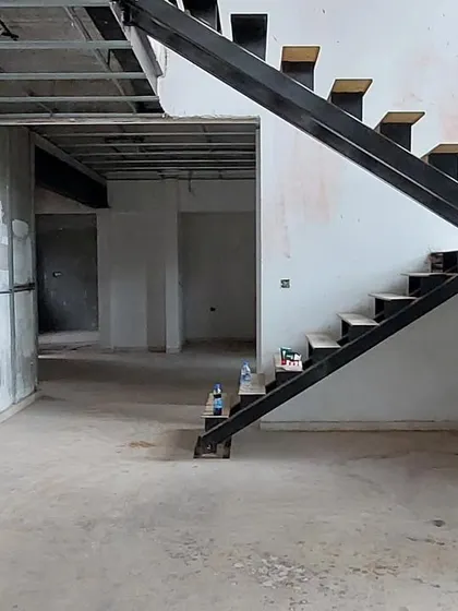 The 'House of Kismish' living area during construction, showing the raw staircase and wall framing.