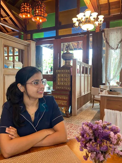 Enjoying a quiet moment in a cafe in Chiang Mai, surrounded by beautiful wooden interiors and colorful stained glass. The atmosphere of a place, its textures, and its use of light are all things I draw upon for home decor inspiration.