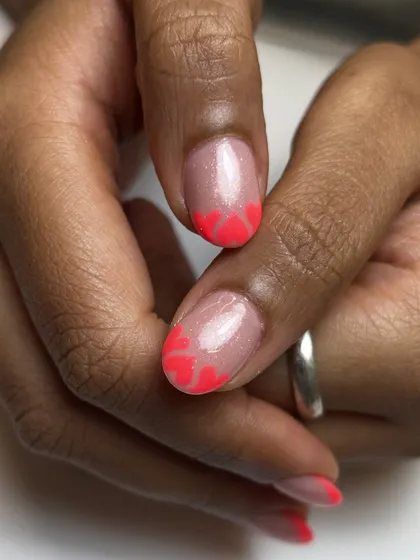 A closer look at the neon pink heart-shaped French tips. It's a super cute and playful design, perfect for adding a pop of color and fun.