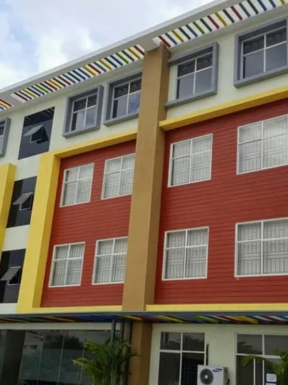 A frontal view of the colorful facade at Asia Pacific World School, highlighting the rhythmic pattern of windows and colored panels.