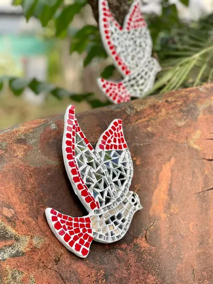 A mosaic bird wall hanger, crafted from hand-cut ceramic tiles and mirrors. This piece shines and reflects light, exuding a sense of freedom and freshness on any surface.