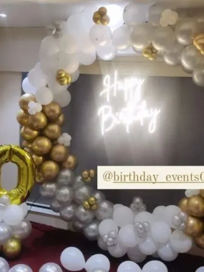 Celebrating a 50th birthday with a touch of class. This gold, silver, and white balloon ring is complemented by a large champagne bottle foil balloon.