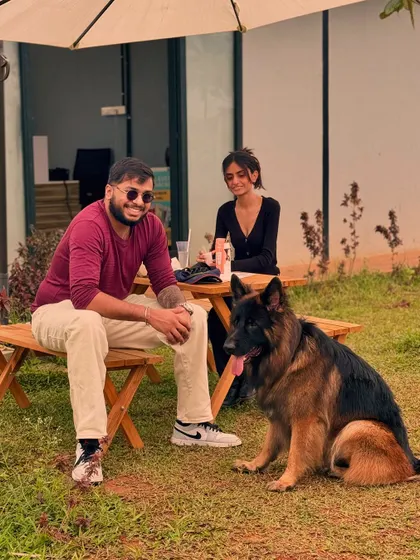 A perfect weekend scene: good company and a happy dog relaxing by the picnic table at our outdoor cafe.
