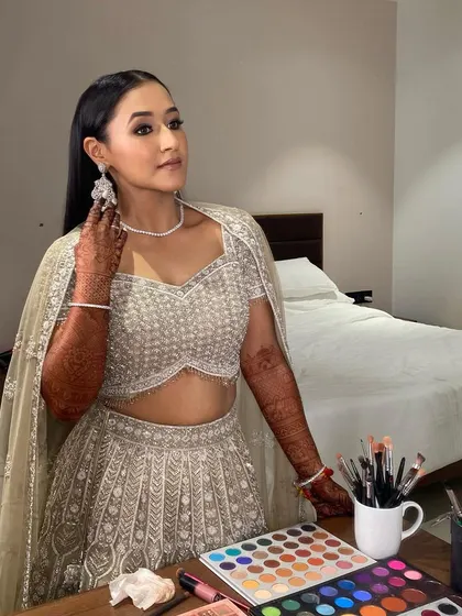 A moment of reflection before the sangeet. This shot captures the sleek hairstyle and the smokey eye glam, with my makeup kit ready for any final touches.