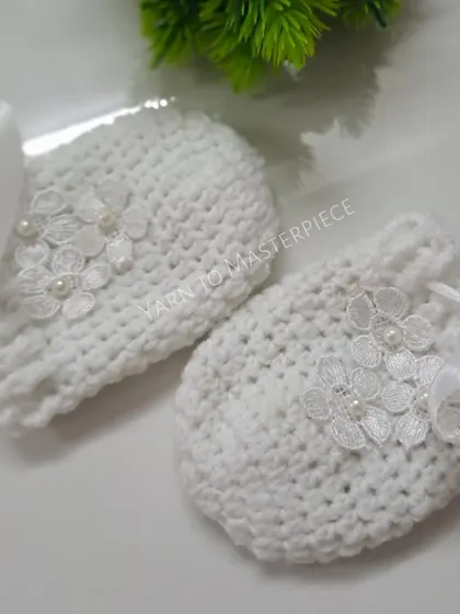 To keep tiny hands warm and prevent scratches, I make these matching white mittens. They feature the same delicate lace flower and pearl design as the booties.
