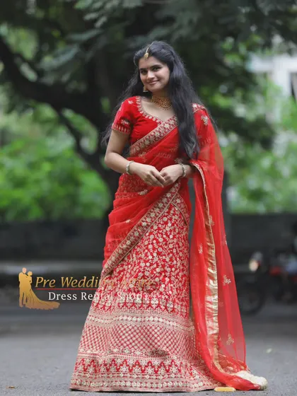 A classic red lehenga with gold embroidery, perfect for a traditional pre-wedding photoshoot.