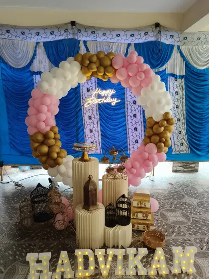 A pink, white, and gold balloon ring setup inside a tent, showing how I can adapt my decorations for different venues and spaces.