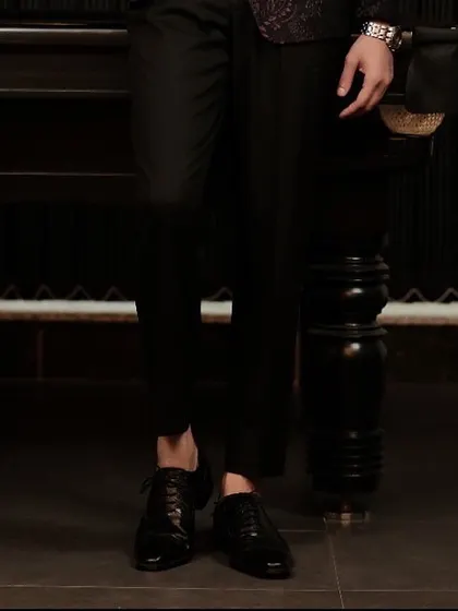 The cropped trouser and classic oxford shoe pairing completes the sharp, modern silhouette of our burgundy tuxedo ensemble.