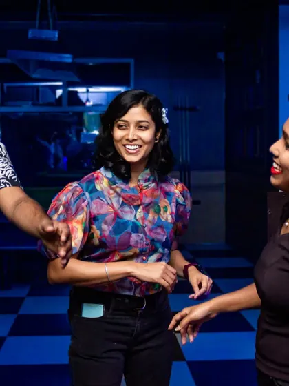 Friends dancing and interacting on the checkered floor. The space is designed to encourage socializing and fun.