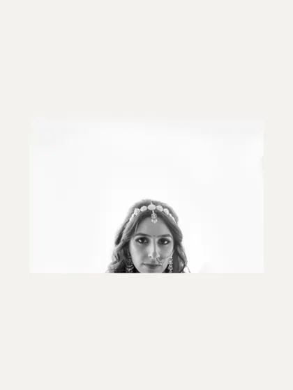 A minimalist black and white portrait of the bride. The composition, with her face at the bottom of the frame, is artistic and intriguing.