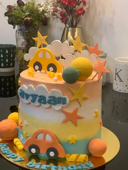 Another view of the sunset ombre car cake. The warm colors and playful decorations make it a cheerful choice for a birthday.