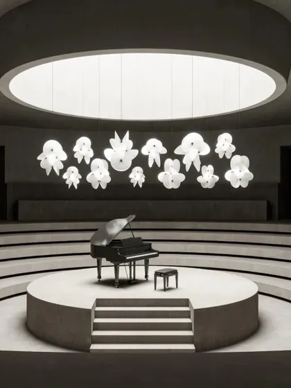 The new, grander scale of the Serpentine Light by Front for Moooi, seen here in a dramatic concert hall setting. The fixture's paper-like forms create an illusion of airy elegance.
