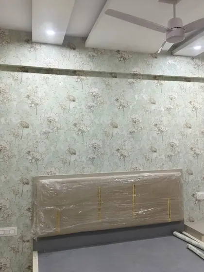 A soft, dandelion-like floral pattern on a light blue background creates a dreamy and peaceful bedroom accent wall. The design is subtle enough to be calming but detailed enough to be interesting.