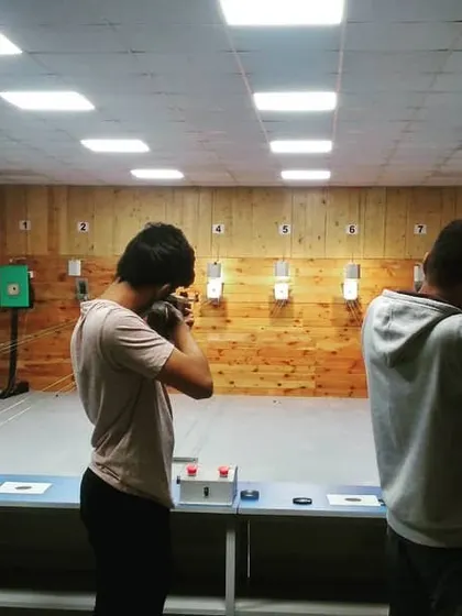 Three guests practice their aim during a recreational shooting session. Notice how each shooter adopts a stable stance to maximize their accuracy.