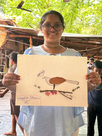A camper proudly presents her artwork of a bird, complete with a speech bubble, showcasing the fun and creativity we encourage.