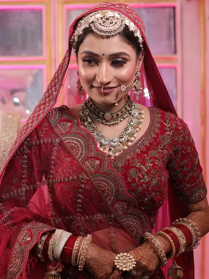 A beautiful candid shot of my bride Varsha. Her makeup features soft, glowing skin and defined eyes, perfectly complementing her traditional red bridal attire and oxidized silver jewelry.