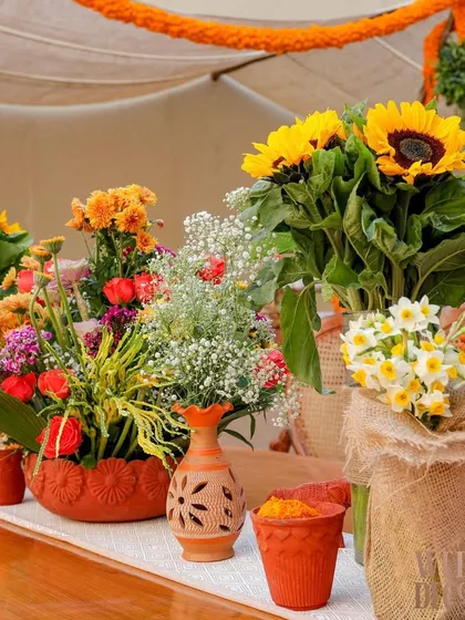 Another look at the floral arrangements on the tables. I used a variety of flowers like sunflowers, baby's breath, and narcissus in different rustic containers to create texture and visual interest.