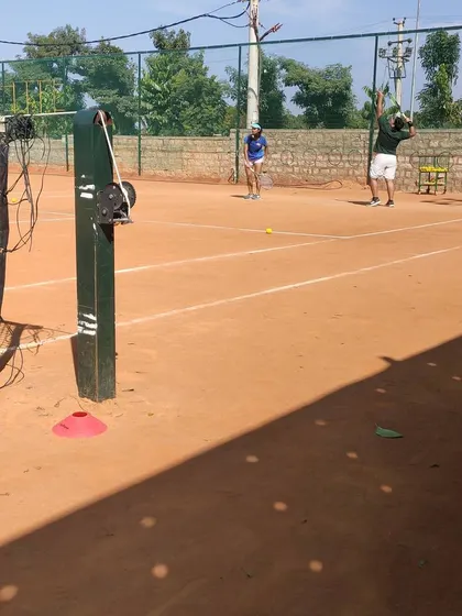 An adult player practices his overhead smash during a drill session.